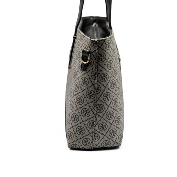 Elegant Tory Burch handbag with a signature pattern and black leather detailing.